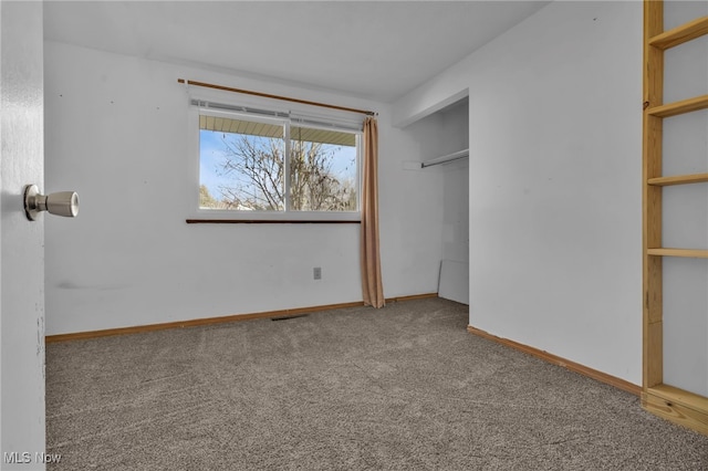 unfurnished bedroom featuring a closet, carpet flooring, visible vents, and baseboards