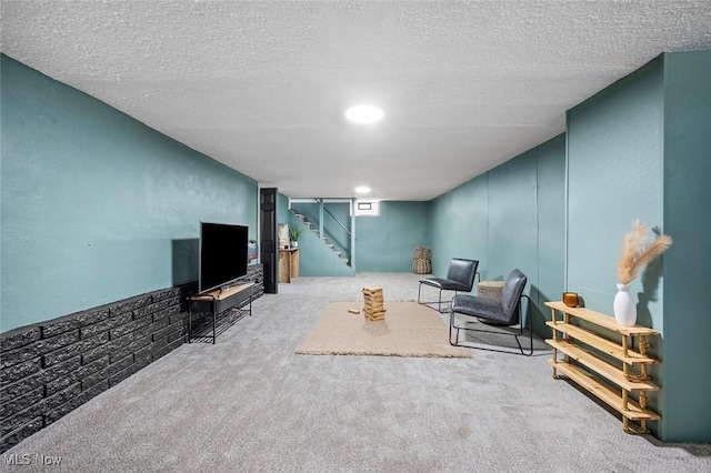 interior space featuring carpet floors, stairs, and a textured ceiling