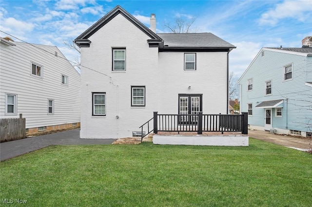 back of property with a yard, brick siding, and a chimney