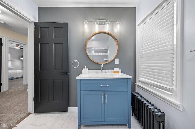 bathroom featuring marble finish floor, radiator heating unit, and vanity