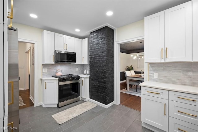 kitchen featuring decorative backsplash, appliances with stainless steel finishes, dark wood-type flooring, light countertops, and white cabinetry