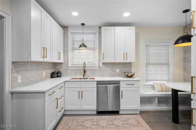 kitchen with pendant lighting, decorative backsplash, white cabinetry, a sink, and dishwasher