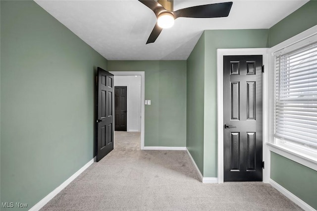 unfurnished bedroom with carpet, a ceiling fan, and baseboards