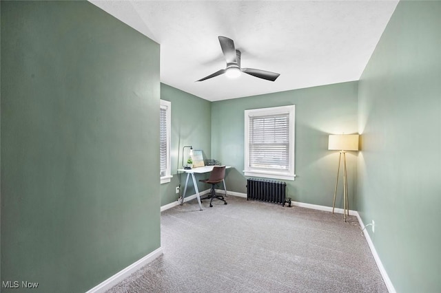 office area with a ceiling fan, carpet, radiator, and baseboards