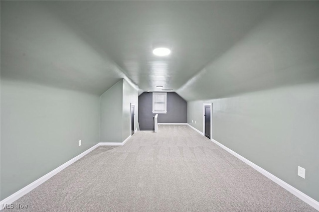 additional living space featuring vaulted ceiling, carpet flooring, and baseboards