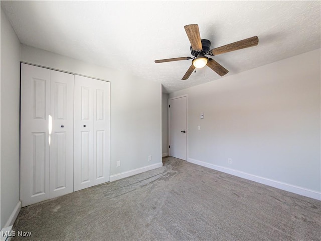 unfurnished bedroom featuring a textured ceiling, carpet flooring, a ceiling fan, baseboards, and a closet