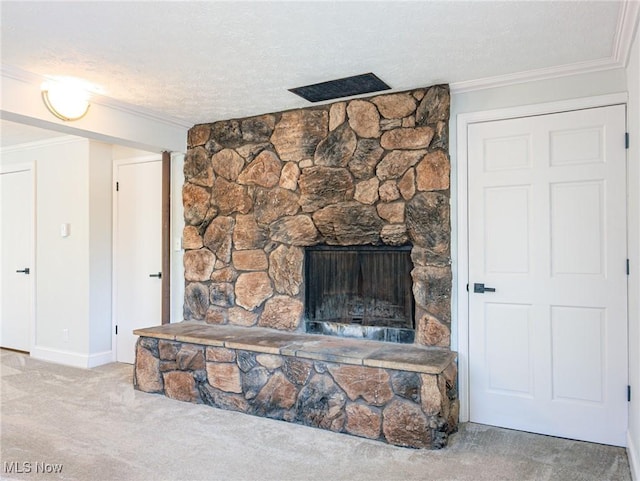 interior details featuring carpet floors, ornamental molding, a stone fireplace, and a textured ceiling