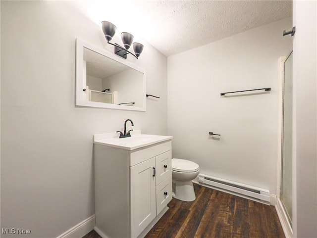 full bathroom featuring toilet, wood finished floors, a textured ceiling, vanity, and a baseboard heating unit