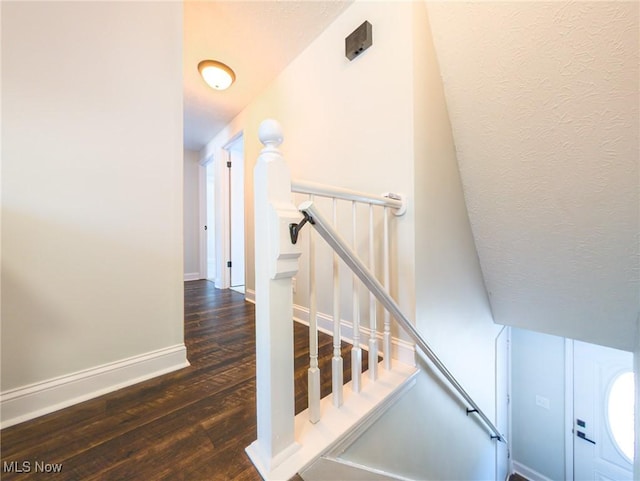 stairway featuring baseboards and wood finished floors