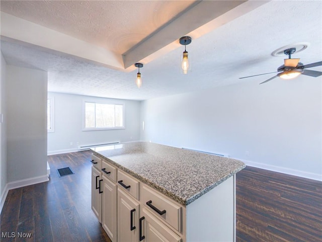 kitchen with a textured ceiling, a kitchen island, baseboards, open floor plan, and dark wood finished floors