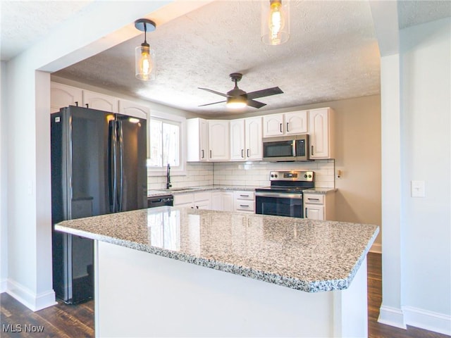 kitchen with tasteful backsplash, dark wood-style floors, black appliances, and light stone countertops