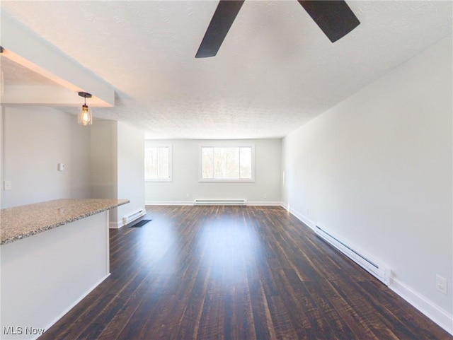 unfurnished living room featuring a baseboard radiator, baseboards, dark wood finished floors, and a textured ceiling