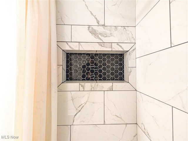 interior details featuring tiled shower