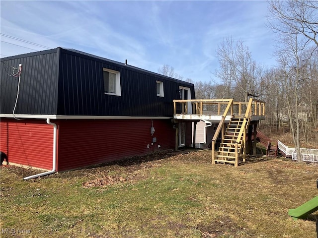 back of property featuring metal roof, stairway, a deck, and a yard