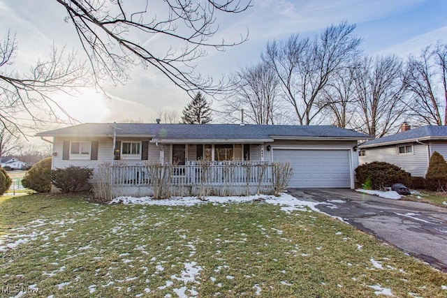 ranch-style house with covered porch, a yard, driveway, and a garage