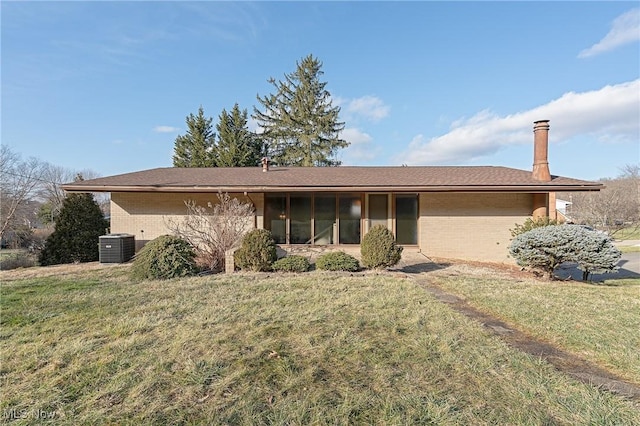 single story home featuring a sunroom, a front yard, and brick siding