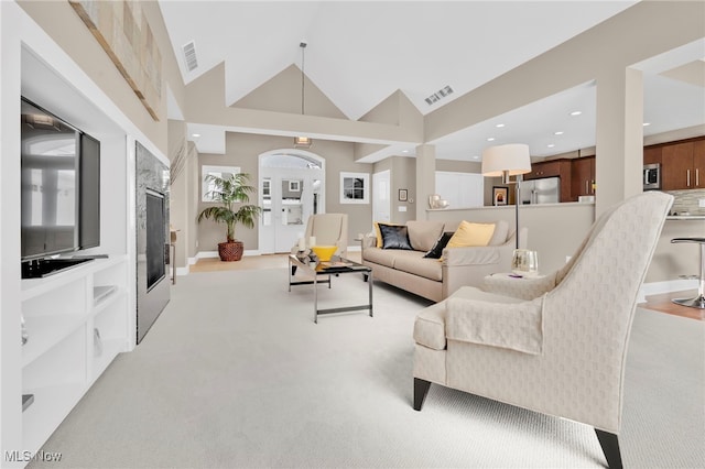 7571 Silverleaf Ct, Sagamore Hills, OH 44067 - living area featuring light colored carpet, a glass covered fireplace, high vaulted ceiling, and recessed lighting