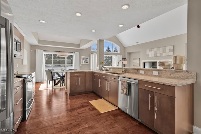 7571 Silverleaf Ct, Sagamore Hills, OH 44067 - kitchen featuring stainless steel appliances, plenty of natural light, dark wood-type flooring, light stone counters, and recessed lighting