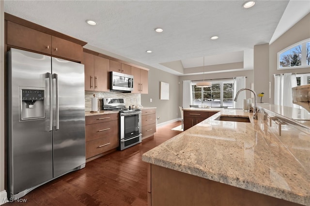 7571 Silverleaf Ct, Sagamore Hills, OH 44067 - kitchen with stainless steel appliances, a raised ceiling, dark wood finished floors, backsplash, and recessed lighting