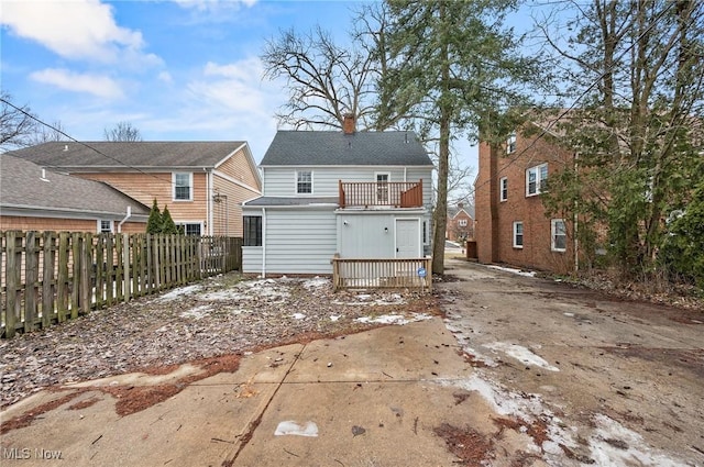 back of property with fence and a chimney