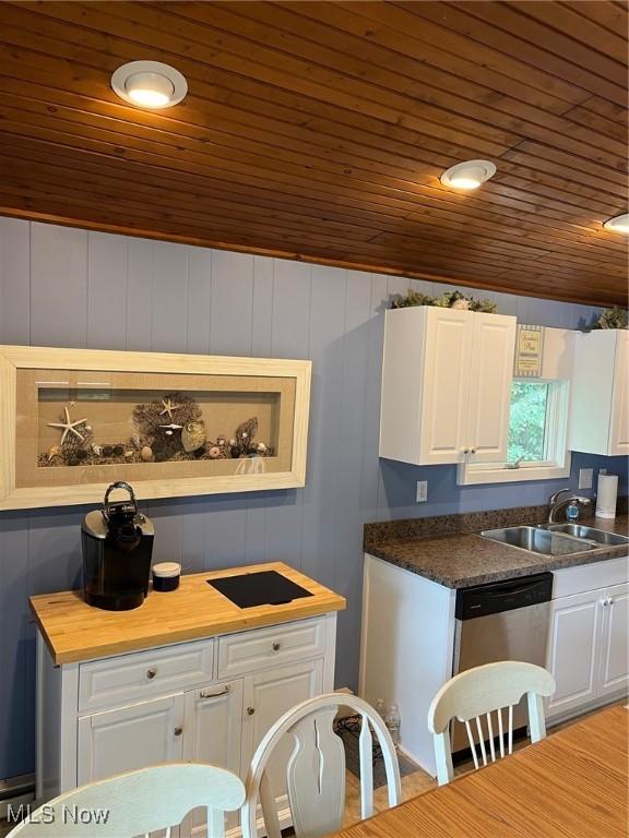 kitchen with wooden ceiling, dishwasher, white cabinets, and a sink