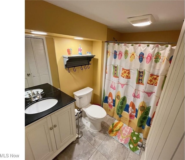 full bath featuring a shower with shower curtain, vanity, and toilet