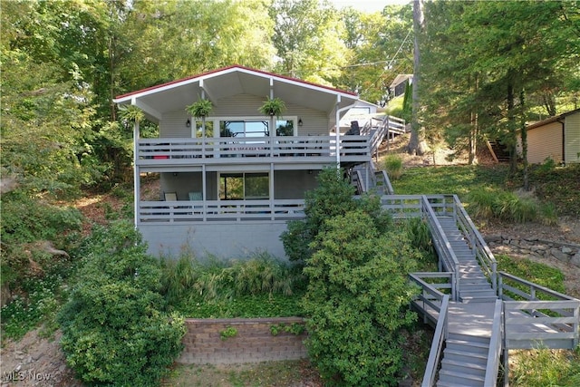 back of house featuring stairway and a wooden deck