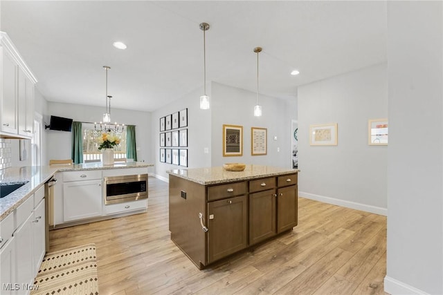 kitchen with stainless steel appliances, white cabinets, and light wood finished floors