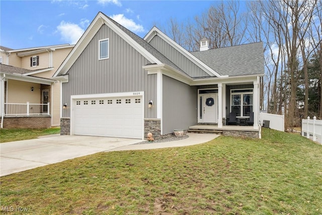 craftsman-style house featuring covered porch, a shingled roof, fence, concrete driveway, and a front yard