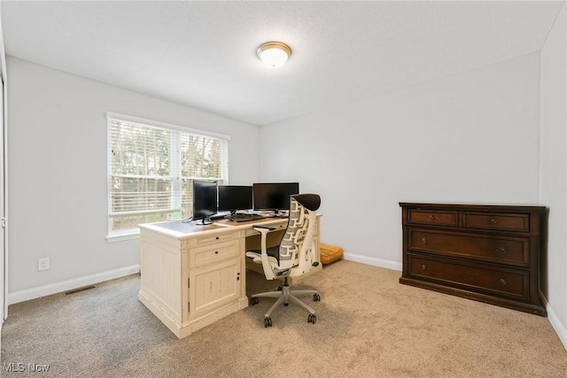 home office with baseboards, visible vents, and light colored carpet