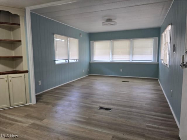 interior space with a healthy amount of sunlight, baseboards, visible vents, and dark wood-style flooring