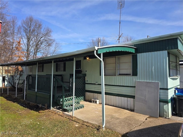 rear view of property with a carport and covered porch