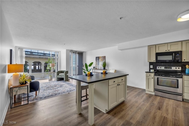 kitchen featuring black microwave, cream cabinets, dark wood-type flooring, stainless steel electric range oven, and dark countertops