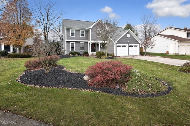 colonial home featuring concrete driveway, a front lawn, and an attached garage