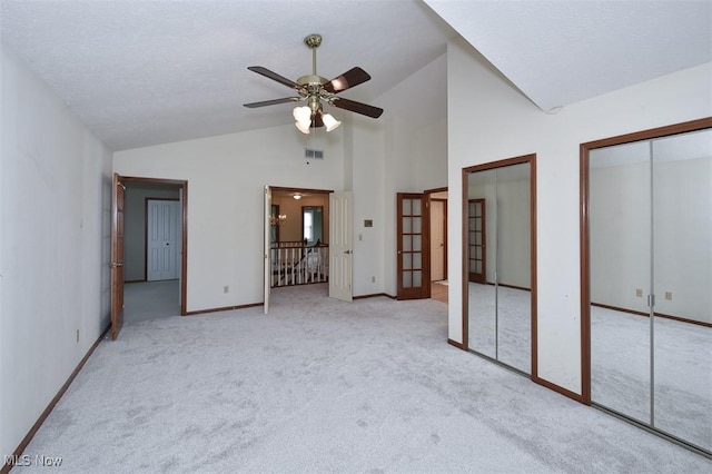 unfurnished bedroom with carpet floors, multiple closets, visible vents, high vaulted ceiling, and baseboards