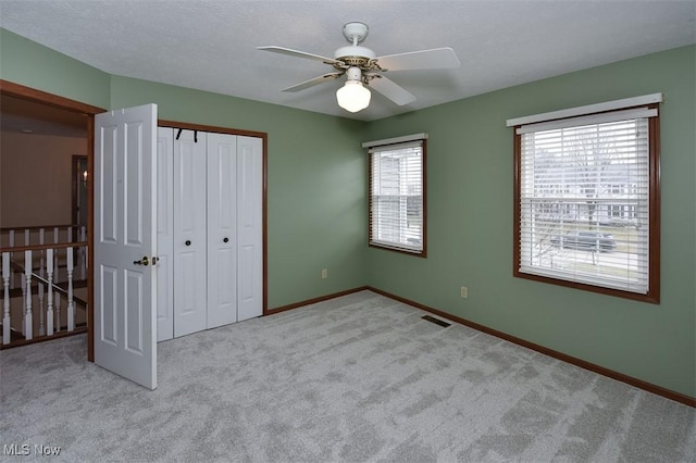 unfurnished bedroom featuring baseboards, carpet, visible vents, and a closet