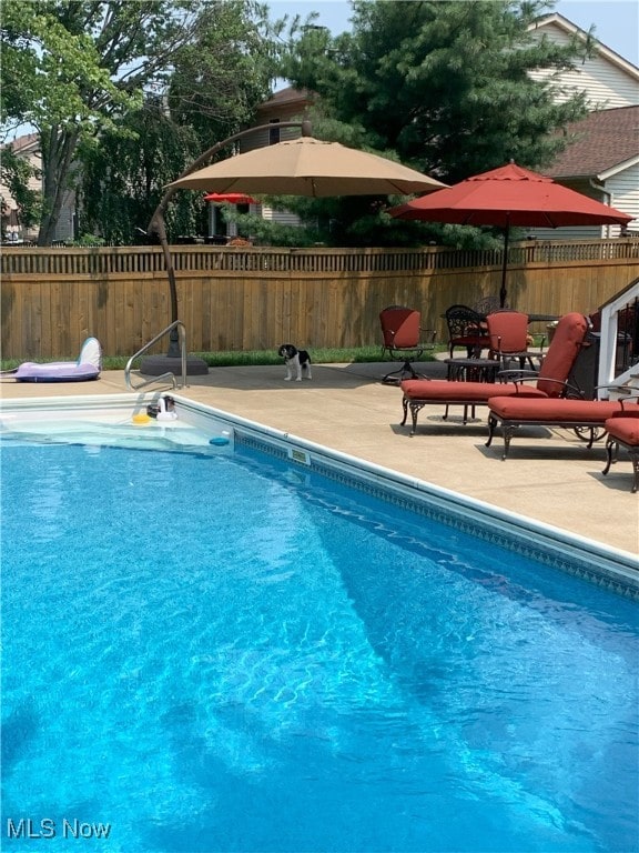 view of pool with a fenced in pool, fence, and a patio