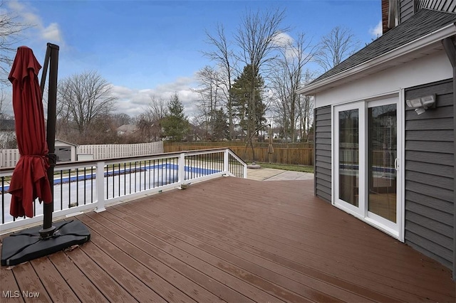 wooden terrace with a fenced backyard and a fenced in pool