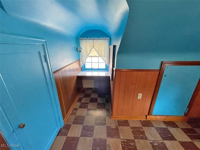 additional living space featuring wooden walls, wainscoting, and tile patterned floors