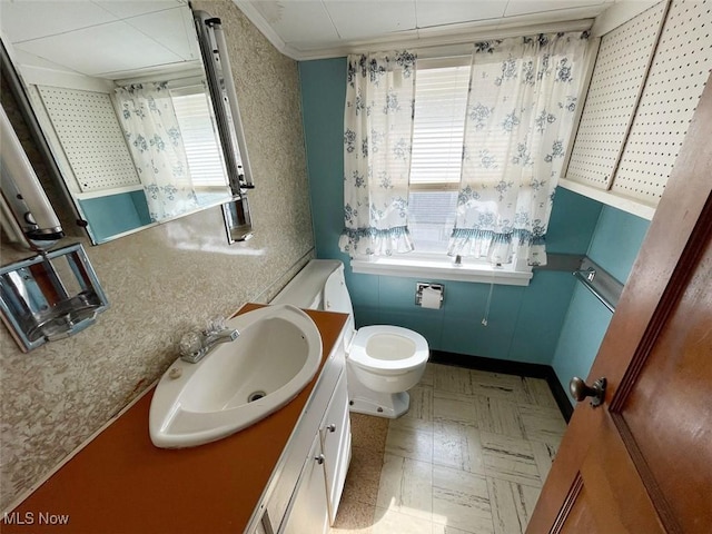 half bathroom featuring toilet, ornamental molding, vanity, and tile patterned floors