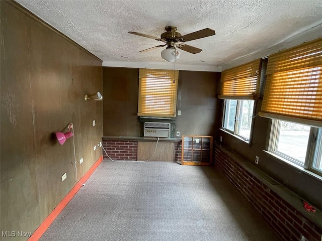 carpeted spare room with a textured ceiling, ceiling fan, and cooling unit