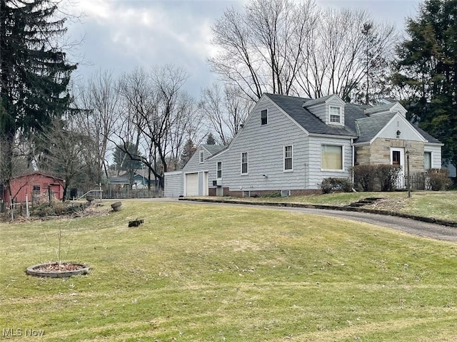 view of side of home with a garage, a yard, and stone siding