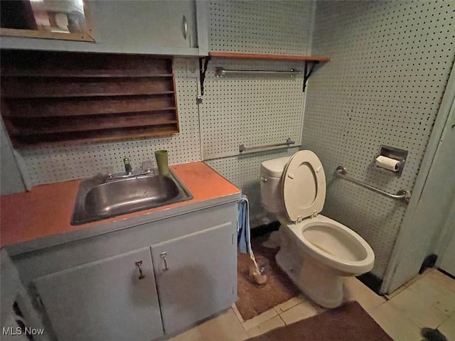 half bath featuring vanity, toilet, and tile patterned floors