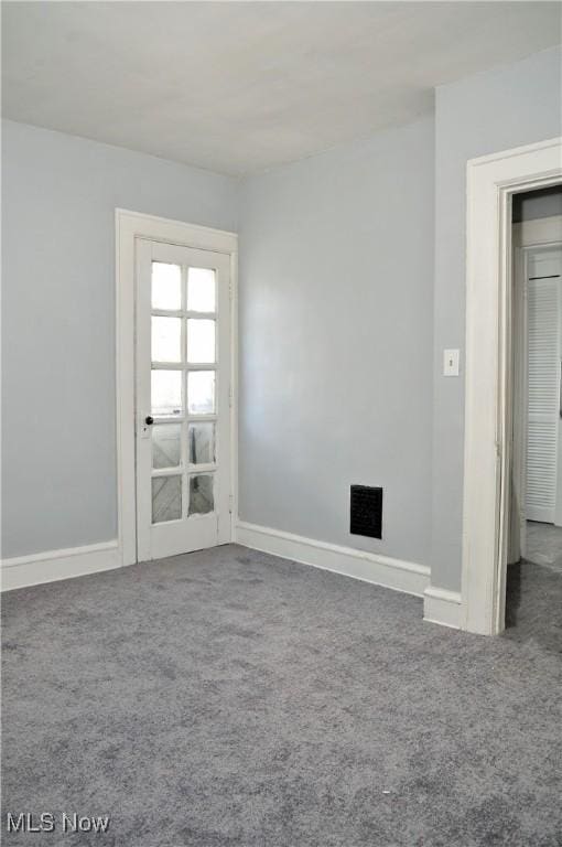 spare room featuring carpet floors and baseboards