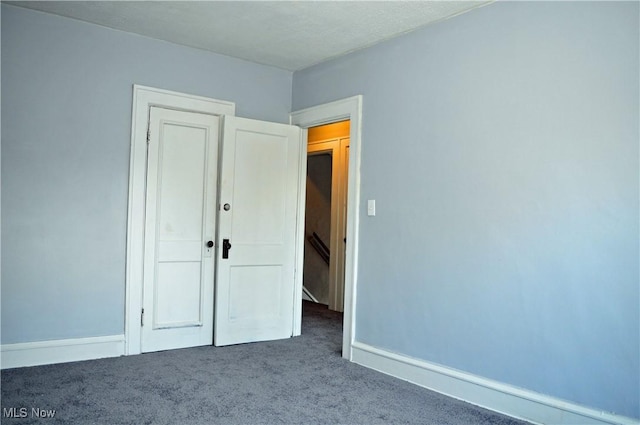 unfurnished bedroom featuring carpet and baseboards