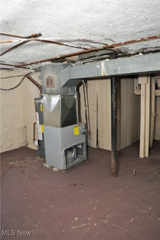 unfinished basement featuring gas water heater and heating unit