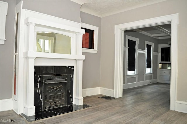 unfurnished living room with wood finished floors, visible vents, and baseboards