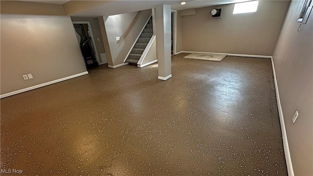 basement with baseboards and stairway