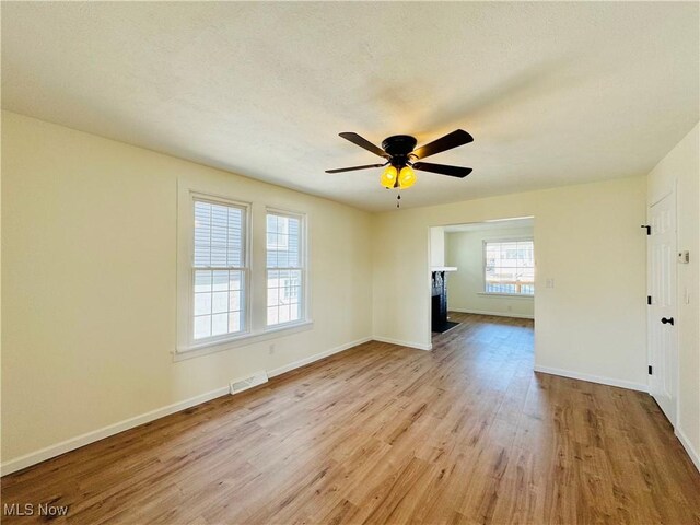 1019 Trenton, Toronto, OH 43964 - unfurnished living room with visible vents, a fireplace with flush hearth, ceiling fan, wood finished floors, and baseboards
