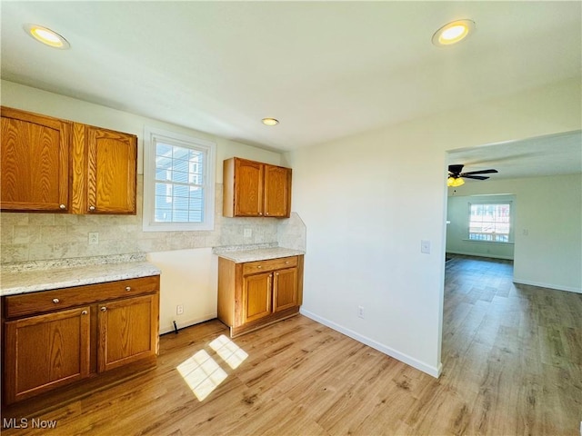 1019 Trenton, Toronto, OH 43964 - kitchen featuring baseboards, light countertops, brown cabinets, decorative backsplash, and light wood finished floors